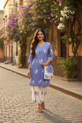 Model wearing periwinkle blue floral block print coord set with matching sling bag